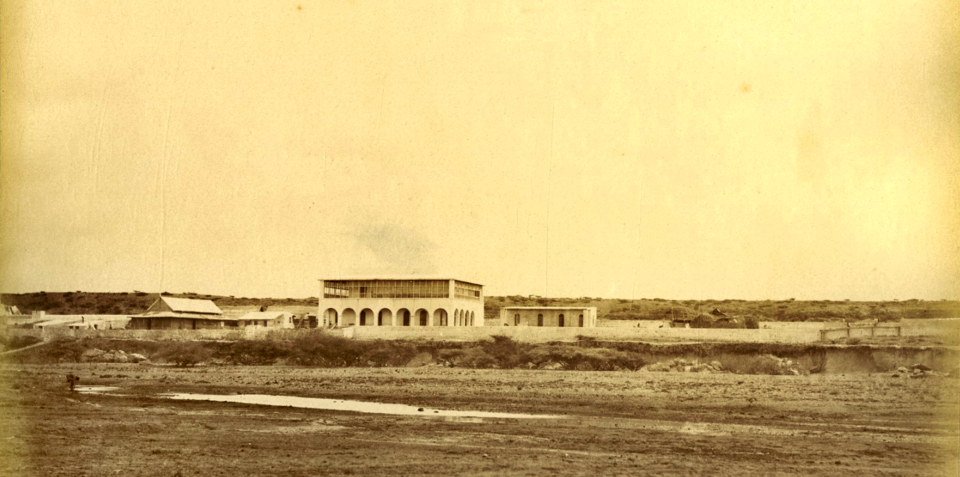 Dépôt de charbon à ciel ouvert à Obock vers 1885 (derrière le mur à droite)